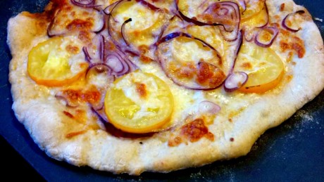 pizza z zoltymi pomidorami i czerwona cebula