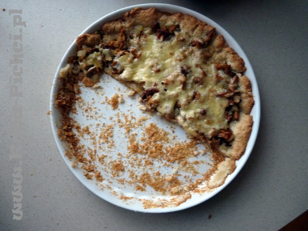 Serowa tarta z kurkami na kruchym cieście oliwnym, pokrojona na porcje