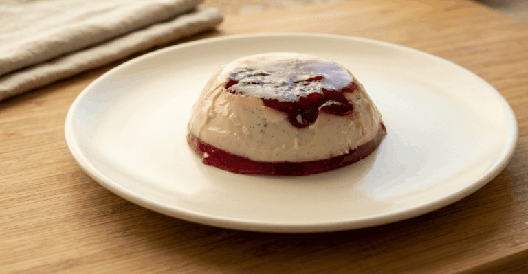 Panna cotta malinowa wyłożona z kokilki na talerz — kremowy deser z malinową warstwą na spodzie