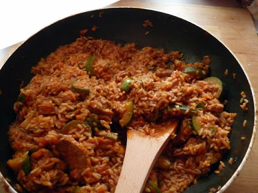 Paella z wołowiną, chorizo i warzywami na ryżu w pomidorowym sosie podana na patelni
