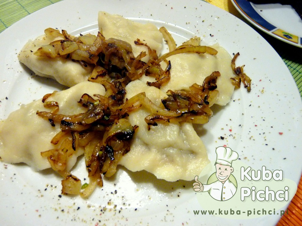Talerz pierogów z mięsem podanych z zeszkloną cebulą