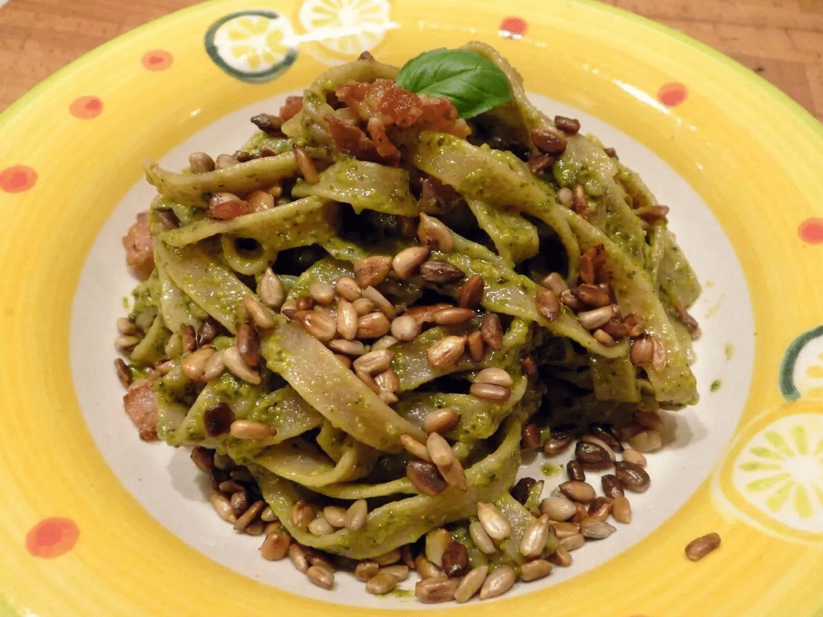 Tagliatelle z pesto i boczkiem posypane prażonym słonecznikiem